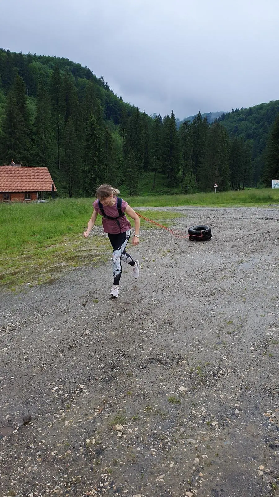 Participantă la un exercițiu de alergare cu rezistență, cu pădurea de brazi în fundal