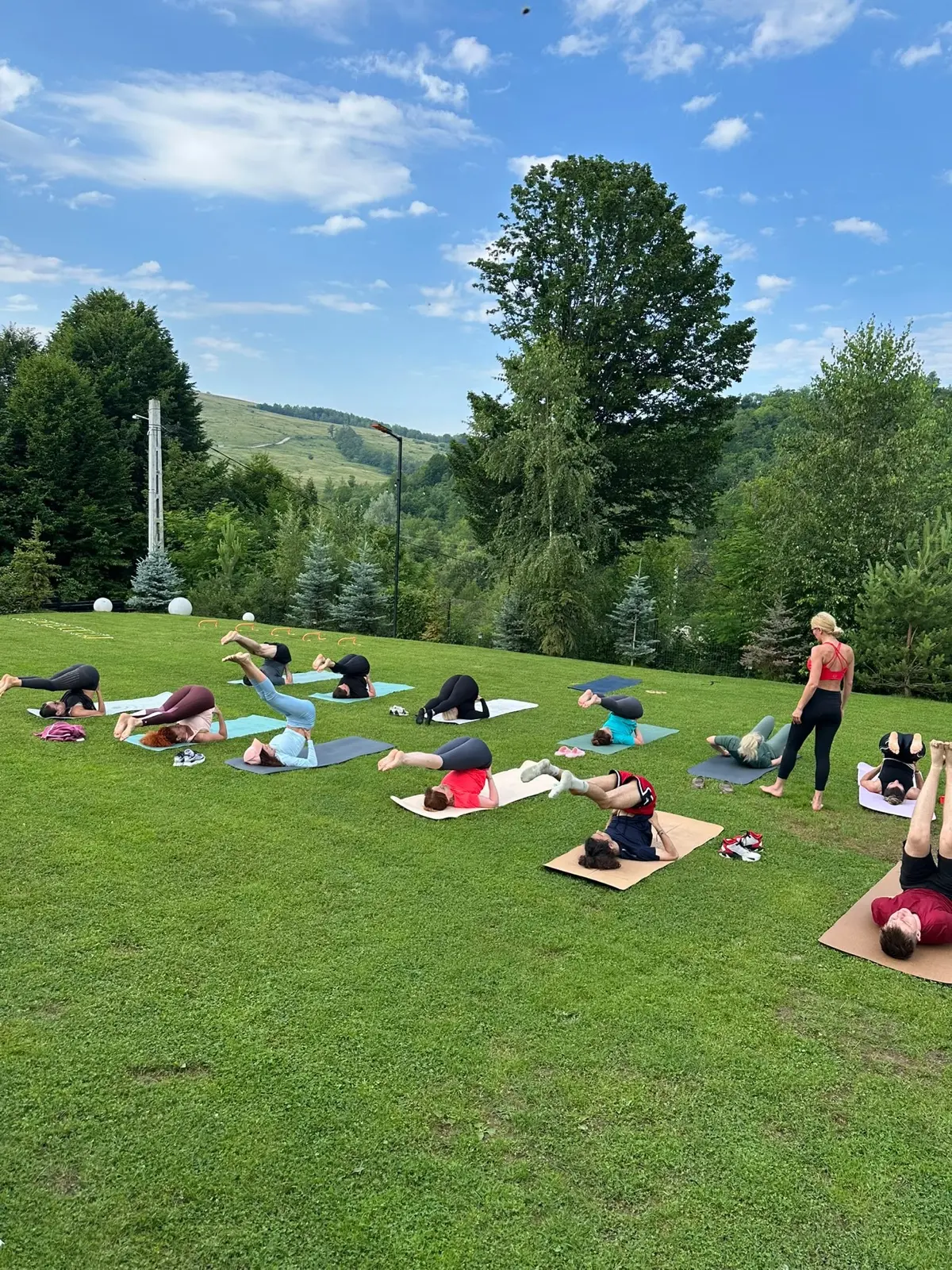 Grup la stretching pe saltele, pe pajiștea pensiunii